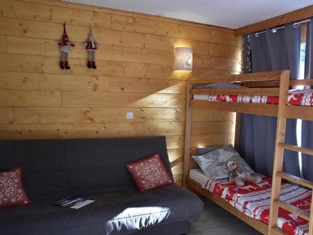 a bedroom with two bunk beds and a couch at Studio Montgenèvre, 1 pièce, 4 personnes - FR-1-266-166 in Montgenèvre