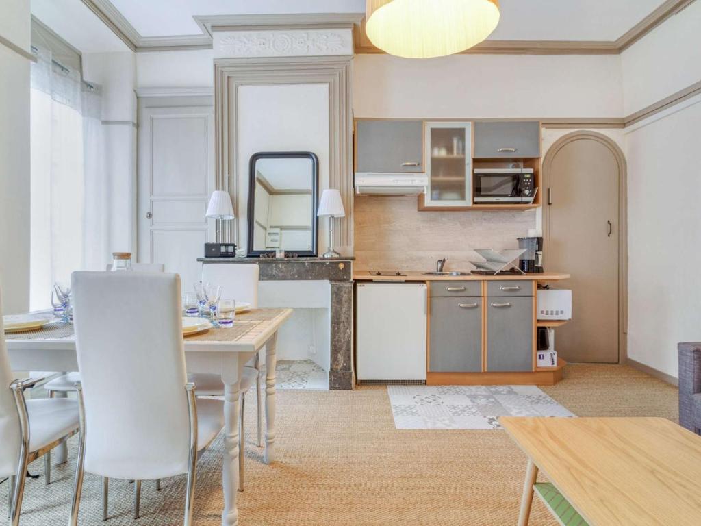 une cuisine et une salle à manger avec une table et des chaises dans l'établissement Appartement Centre Cauterets 4/6 pers avec Balcon, Cuisine Équipée et Local à Skis - FR-1-401-226, à Cauterets