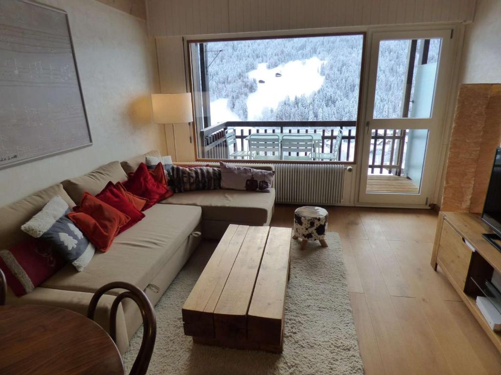 - un salon avec un canapé, une table et une fenêtre dans l'établissement Appartement Le Grand-Bornand, 3 pièces, 6 personnes - FR-1-458-144, au Grand-Bornand