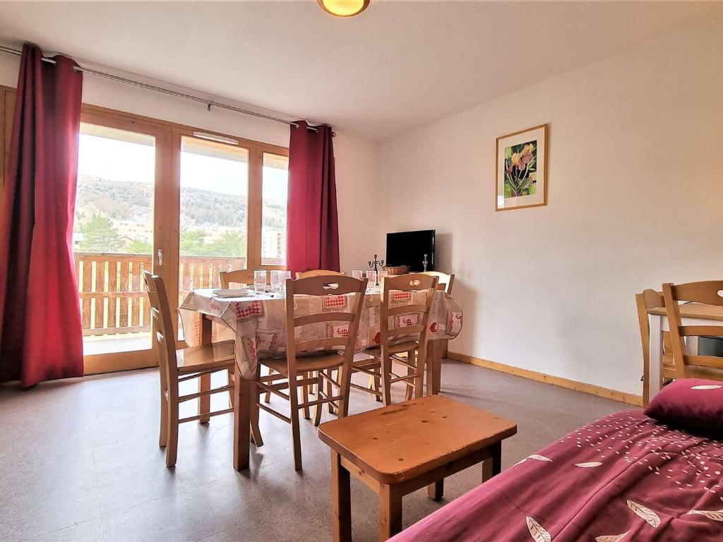 une salle à manger avec une table et des chaises et un balcon dans l'établissement Appartement 8 pers avec balcon, proche commerces et pistes, casier à ski - FR-1-525-199, à Saint-Étienne-en-Dévoluy