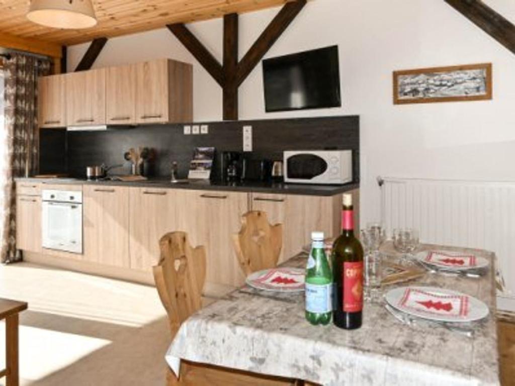 une cuisine avec une table avec deux bouteilles de vin dans l'établissement Charmant T2 à Montgenèvre: Parking, 4 pers., Proche Pistes - FR-1-266-174, à Montgenèvre