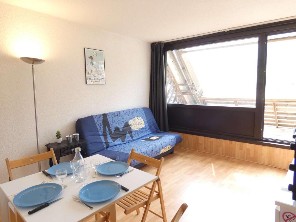 - un salon avec une table et un canapé bleu dans l'établissement Studio Piau-Engaly, 1 pièce, 4 personnes - FR-1-457-297, à Aragnouet