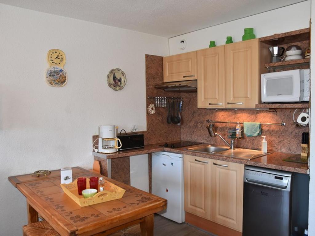 a small kitchen with a wooden table and a counter top at Appartement Montgenèvre, 2 pièces, 6 personnes - FR-1-266-172 in Montgenèvre