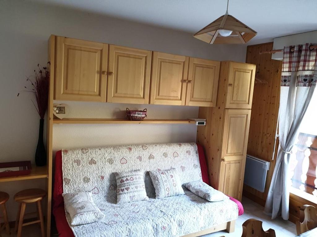 - une chambre avec un lit et des placards en bois dans l'établissement Studio cosy avec balcon, parking et départ skis aux pieds à Saint-Jean-d'Aulps - FR-1-573-48, à Saint-Jean-dʼAulps