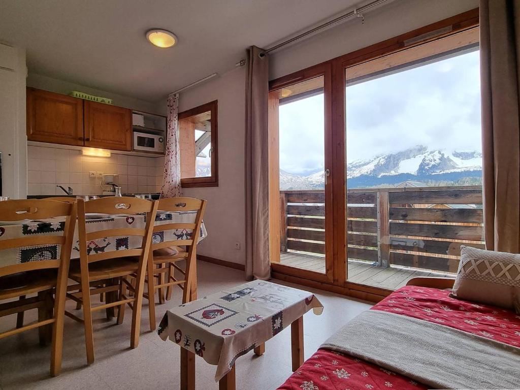 Cette chambre dispose d'une table et de chaises et offre une vue sur la montagne. dans l'établissement Appartement 2 pièces, parking, proche télésiège - Le Dévoluy - FR-1-525-226, à Saint-Étienne-en-Dévoluy