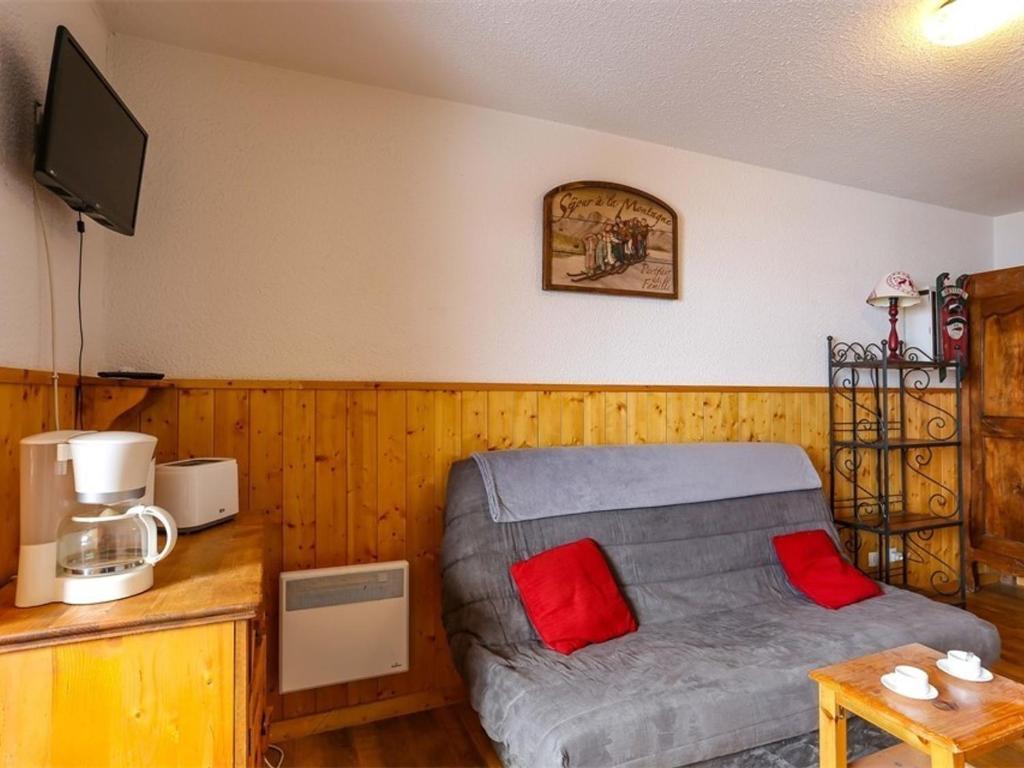 a living room with a gray couch and red pillows at Studio Val Thorens, 2 pièces, 3 personnes - FR-1-637-20 in Val Thorens