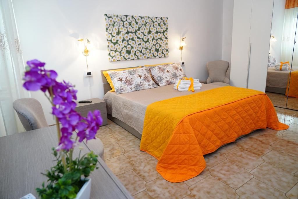 ポルト・チェザーレオにあるB&B La Streaのベッドルーム1室(オレンジ色の毛布付きのベッド1台付)