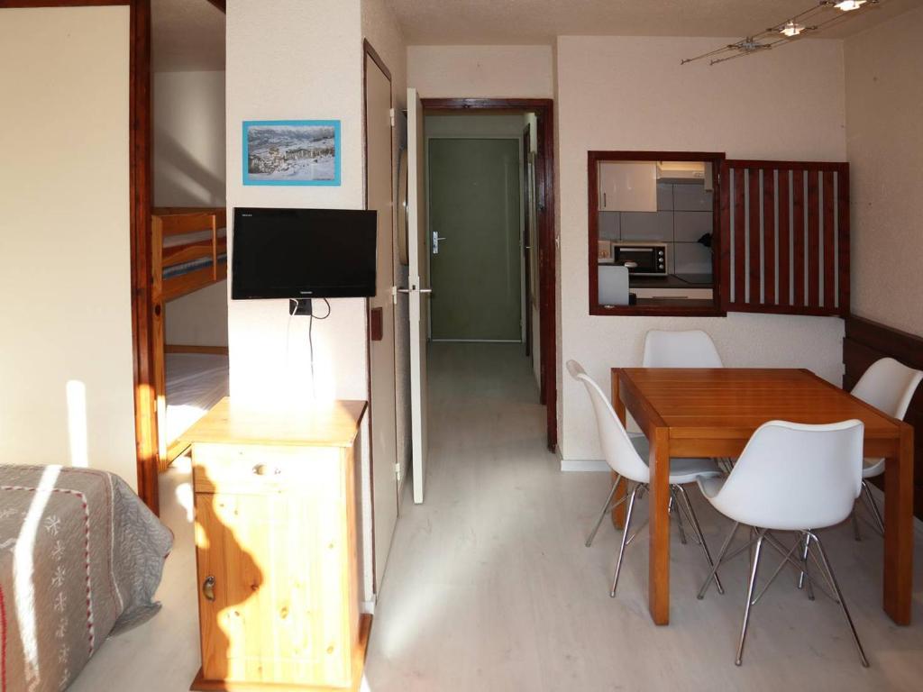 - une chambre avec une table et une télévision dans l'établissement Grand studio skis aux pieds avec balcon, pour 4/5 pers, proche toutes commodités ! - FR-1-322-459, aux Orres