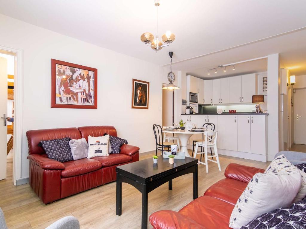 un salon avec un canapé rouge et une table dans l'établissement Appartement 6 personnes, 2 chambres, proche pistes ski, Pla d'Adet - FR-1-296-360, à Saint-Lary-Soulan
