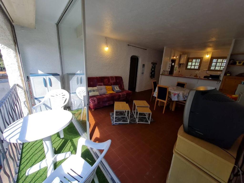uma sala de estar com um sofá, uma mesa e cadeiras em Appartement Argelès-sur-Mer, 3 pièces, 6 personnes - FR-1-225-724 em Argelès-sur-Mer