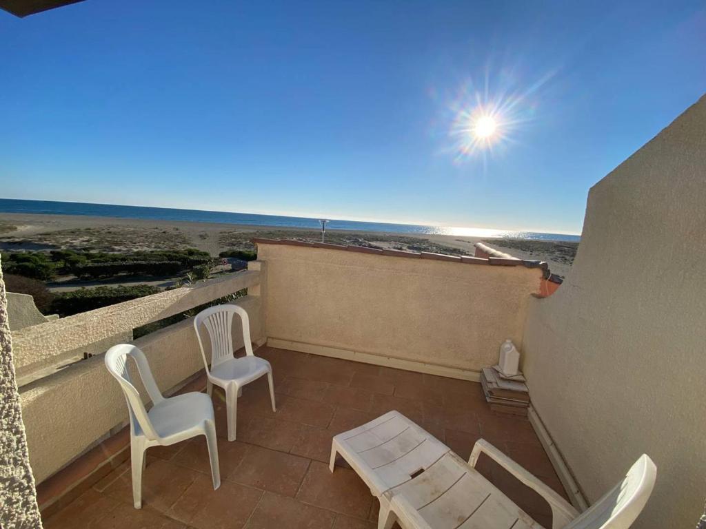 un balcon avec deux chaises et une table sur un immeuble dans l'établissement Villa T2 en Front de Mer avec Parking Privé - FR-1-81-548, à Port-Leucate
