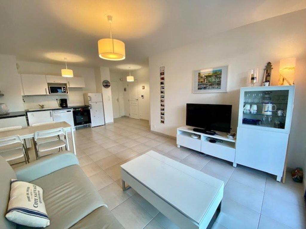un salon avec un canapé et une télévision dans l'établissement Quiberon : Superbe T3 63m² avec Balcon, Parking, et WIFI – Proche Thalasso, Animaux Acceptés ! - FR-1-478-206, à Quiberon