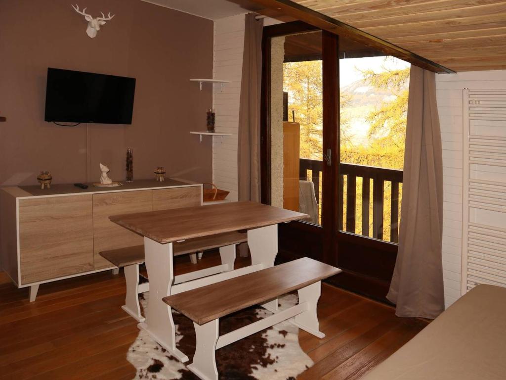 Cette chambre dispose d'un bureau et d'un balcon avec une télévision. dans l'établissement Studette rénovée proche pistes et centre Les Orres - FR-1-322-465, aux Orres
