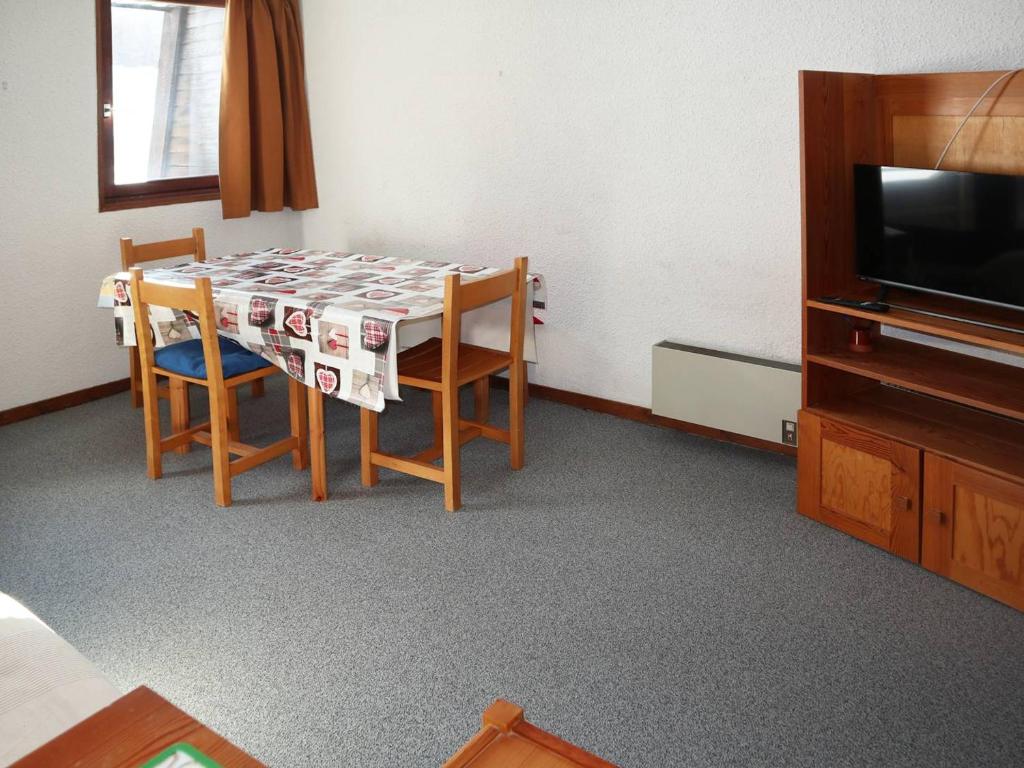 une table à manger avec deux chaises et une télévision dans l'établissement Studio skis aux pieds, 4 pers, balcon - FR-1-322-472, aux Orres
