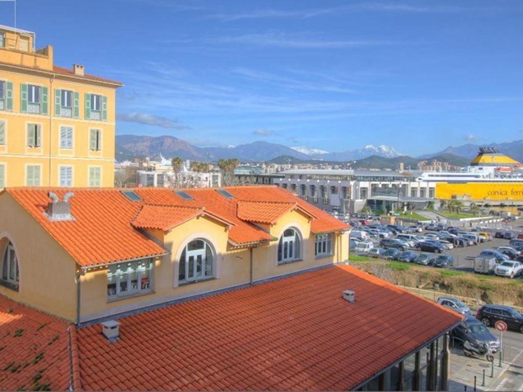 a building with an orange roof with a parking lot at Appartement Ajaccio, 1 pièce, 2 personnes - FR-1-61-473 in Ajaccio