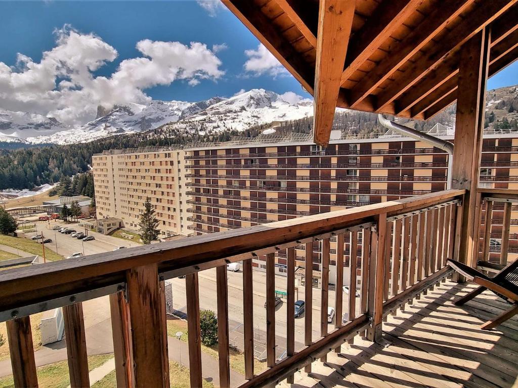 d'un balcon avec vue sur un bâtiment avec des montagnes enneigées. dans l'établissement Appartement 4 pièces avec WiFi, Animaux admis, Parking gratuit proche des pistes - FR-1-525-240, à Saint-Étienne-en-Dévoluy