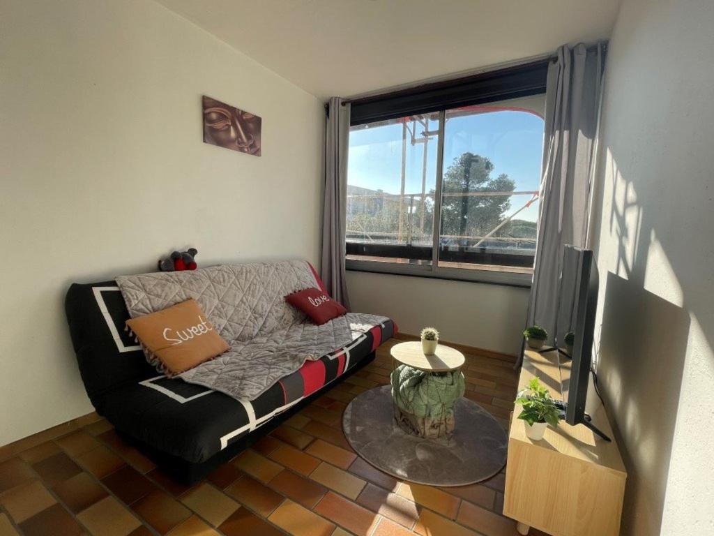 een woonkamer met een bank en een groot raam bij Appartement Saint-Cyprien, 2 pièces, 4 personnes - FR-1-225D-131 in Saint-Cyprien