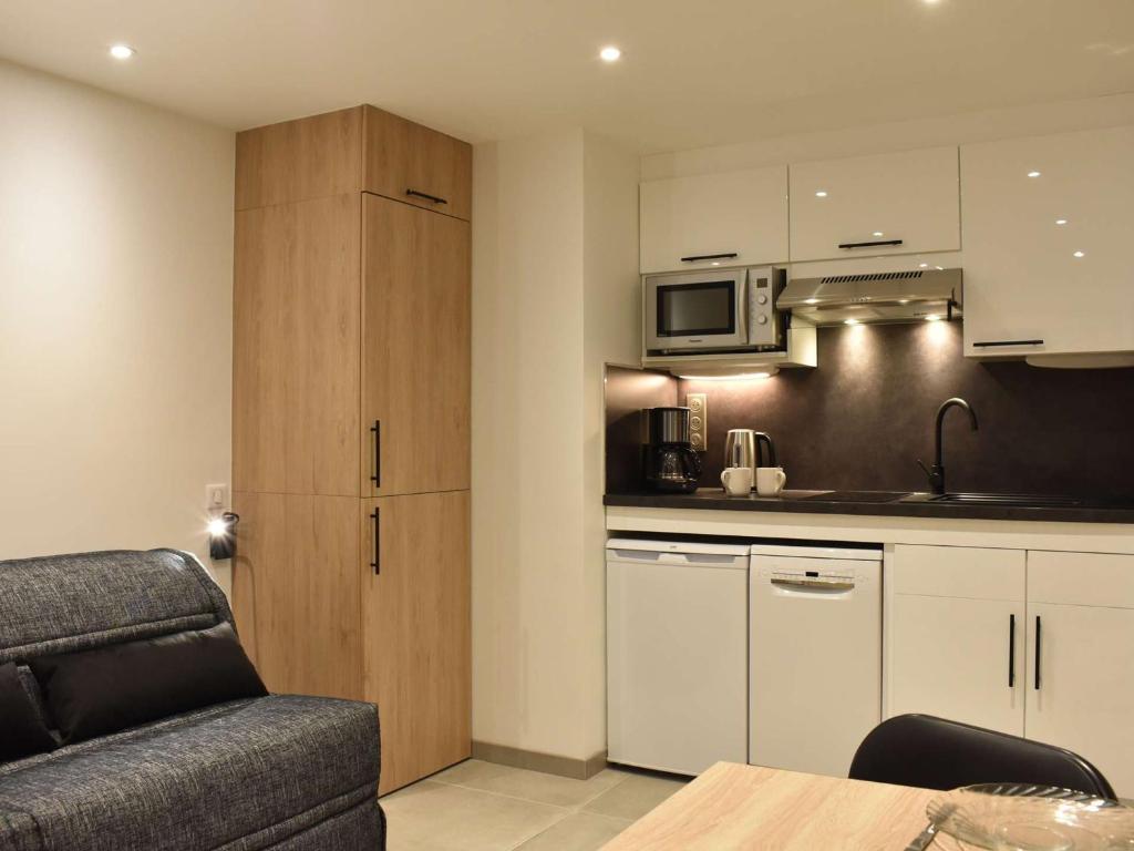 ein Wohnzimmer mit einem Sofa und einer Küche in der Unterkunft Appartement Méribel, 1 pièce, 2 personnes - FR-1-180-572 in Les Allues