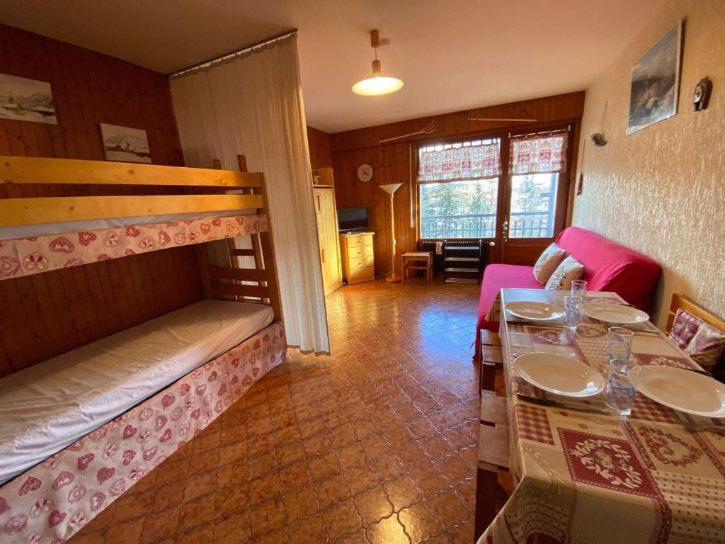 een kamer met een eettafel en een stapelbed bij Appartement Le Grand-Bornand, 1 pièce, 4 personnes - FR-1-241-239 in Le Grand-Bornand