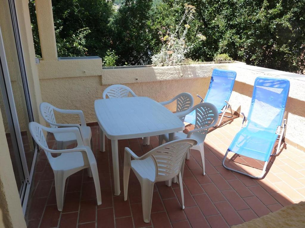 une table et des chaises assises sur une terrasse dans l'établissement Appartement Amélie-les-Bains-Palalda, 3 pièces, 4 personnes - FR-1-659-28, à Amélie-les-Bains-Palalda