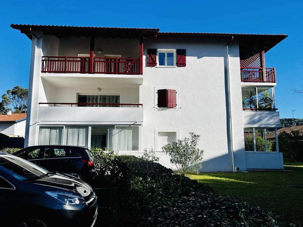 una casa blanca con un coche aparcado delante de ella en Appartement Cambo-les-Bains, 2 pièces, 2 personnes - FR-1-495-102, en Cambo-les-Bains