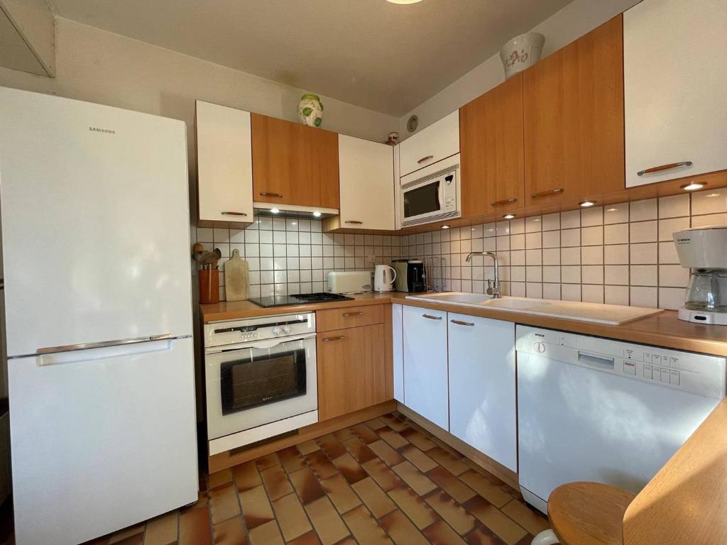 a kitchen with white appliances and wooden cabinets at Appartement Briançon, 3 pièces, 6 personnes - FR-1-330C-124 in Briançon