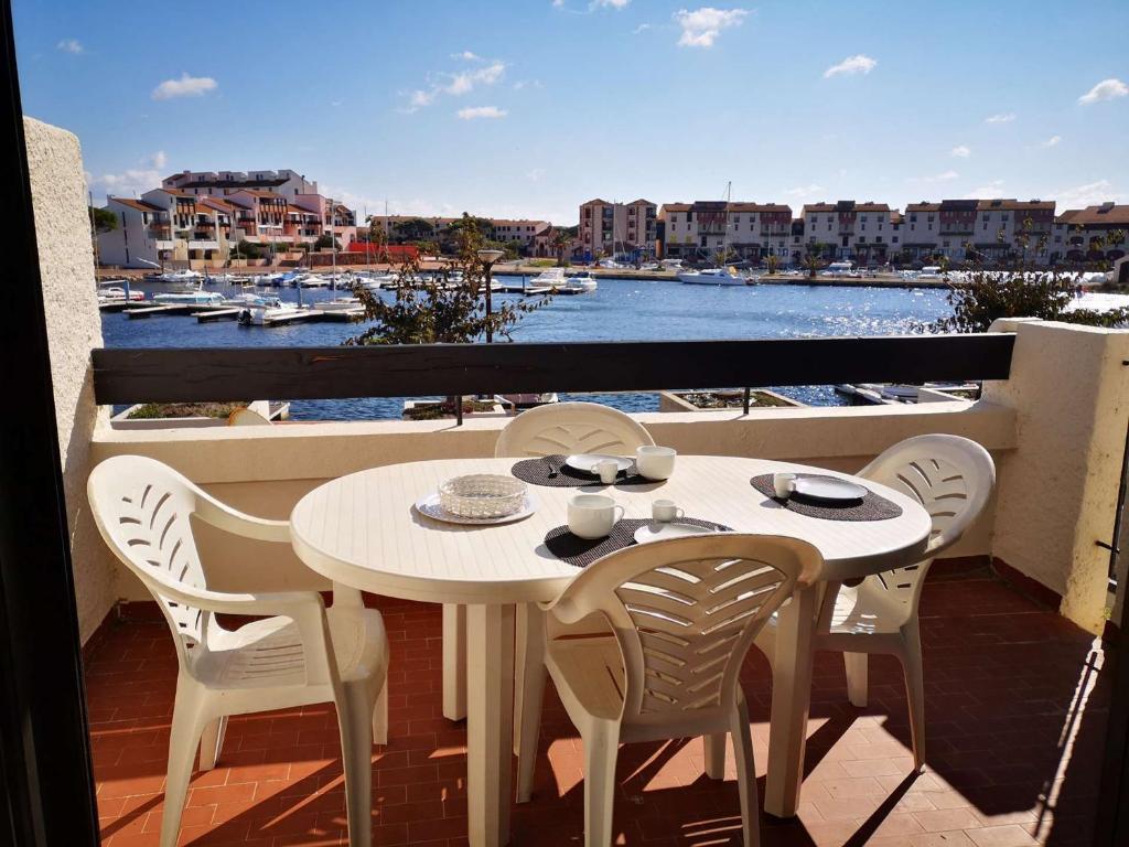 d'une table et de chaises sur un balcon avec vue sur le port. dans l'établissement Appartement T2 pour 5 pers avec piscine et parking - Le Barcarès - FR-1-195-88, au Barcarès