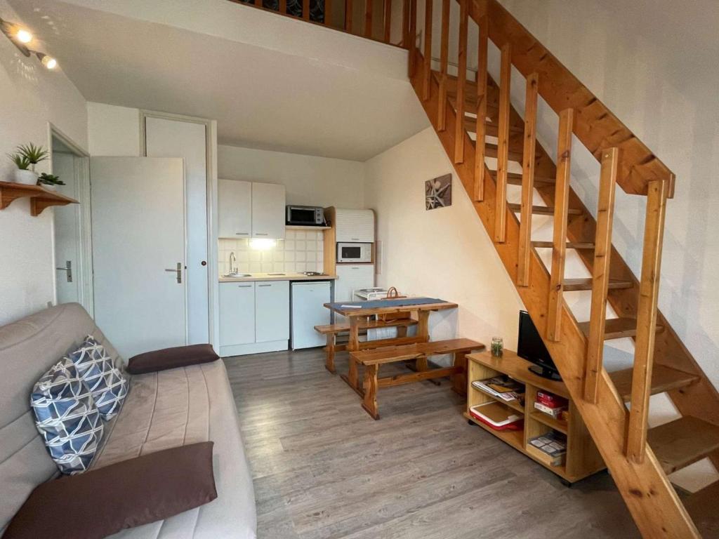 un salon avec un escalier et une cuisine dans l'établissement Appartement cosy avec piscine, terrasse et parking - 250m de la plage - 6 pers. - FR-1-225D-141, à Saint-Cyprien