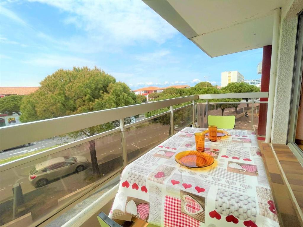- une table sur un balcon avec vue sur la rue dans l'établissement Studio cabine à 2 pas de la plage, parking et animaux admis - FR-1-225D-142, à Saint-Cyprien