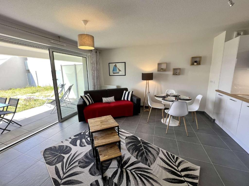 ein Wohnzimmer mit einem roten Sofa und einem Tisch in der Unterkunft Appartement Étel, 2 pièces, 4 personnes - FR-1-479-126 in Étel