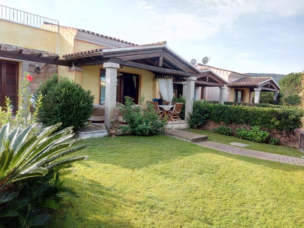 a house with a lawn in front of it at Villa Baia Sant Anna in Tanaunella