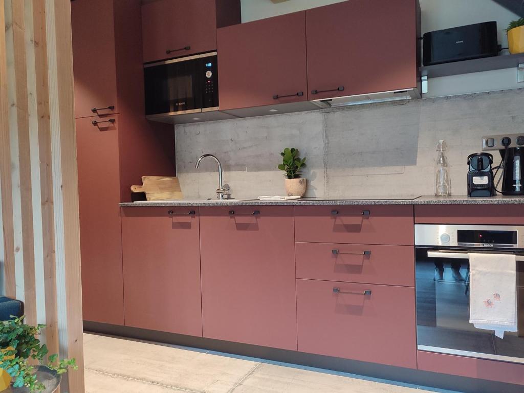- une cuisine avec des placards rouges et un évier dans l'établissement Appartement Morzine, 3 pièces, 4 personnes - FR-1-627-64, à Morzine