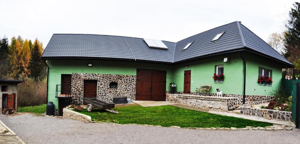 a green house with a black roof at Farma Opačitá in Valaská Belá