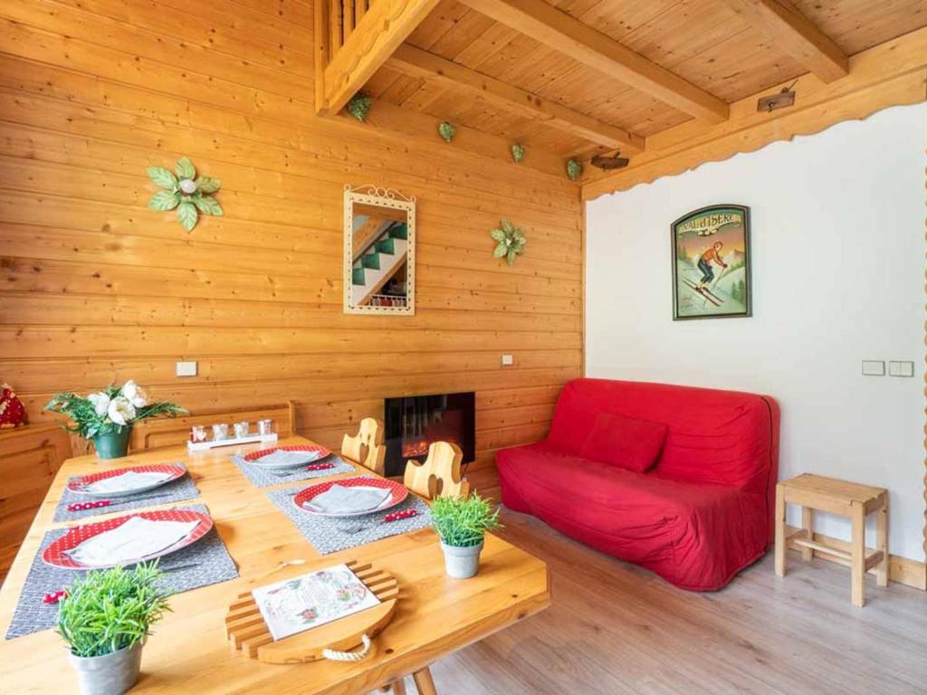 uma sala de estar com um sofá vermelho e uma mesa em Appartement Valmorel, 3 pièces, 6 personnes - FR-1-291-823 em Valmorel