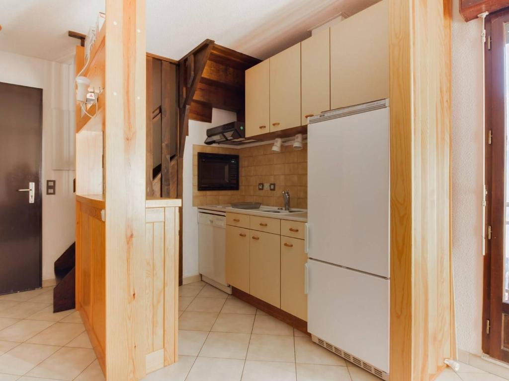 a small kitchen with a white refrigerator and cabinets at Appartement Esquièze-Sère, 3 pièces, 4 personnes - FR-1-402-82 in Esquièze - Sère