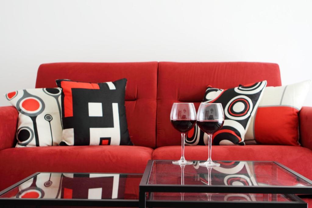 eine rote Couch mit zwei Gläsern Wein auf dem Tisch in der Unterkunft Nonna Maria Guest House in Arezzo