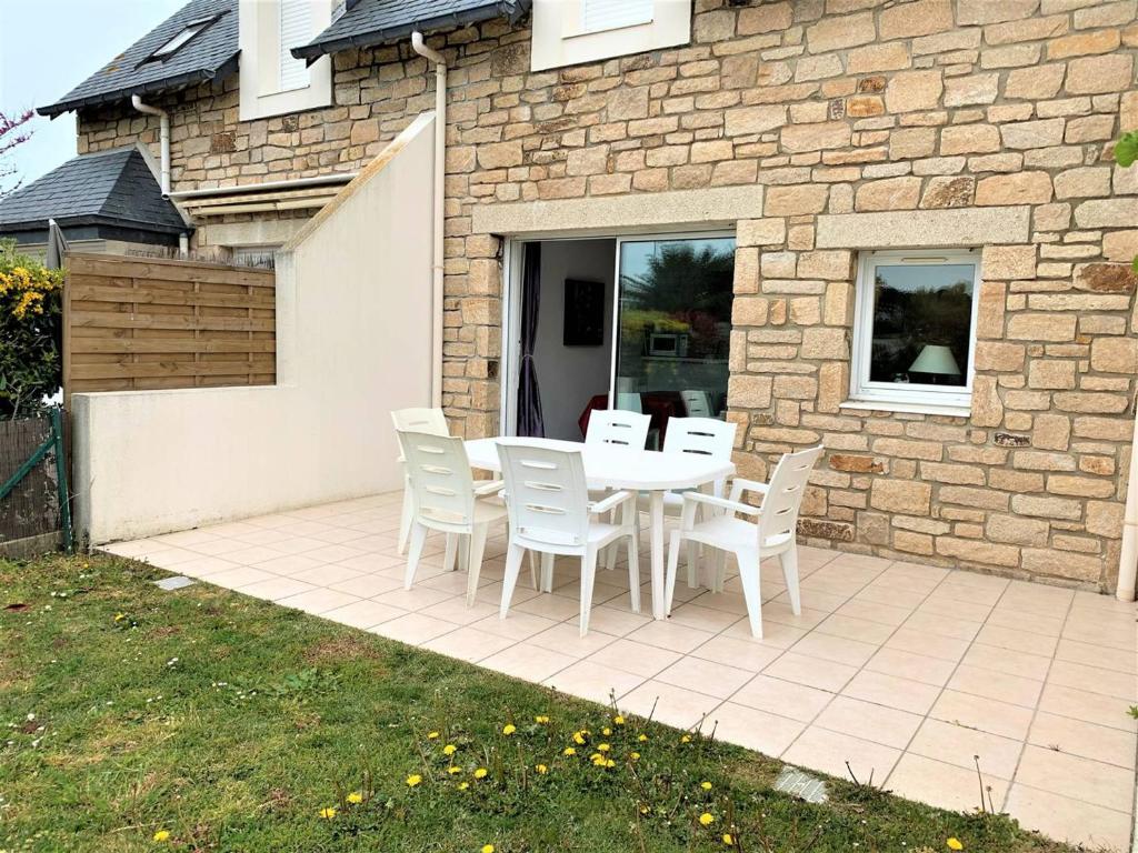 a white table and chairs on a patio at Villa Quiberon, 3 pièces, 6 personnes - FR-1-478-30 in Quiberon