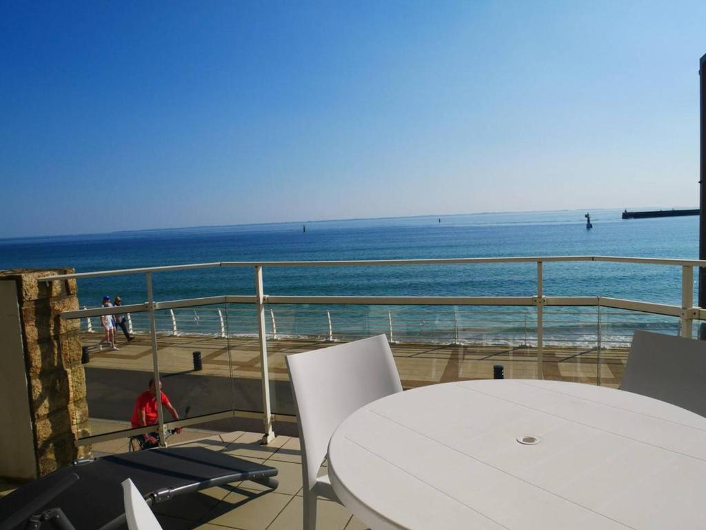 uma mesa e cadeiras numa varanda com vista para o oceano em Studio Quiberon, 1 pièce, 3 personnes - FR-1-478-41 em Quiberon