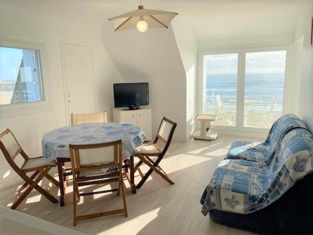 une salle à manger avec une table, des chaises et une télévision dans l'établissement Quiberon - Appartement 2 pièces - 3 pers - Animaux acceptés - FR-1-478-81, à Quiberon