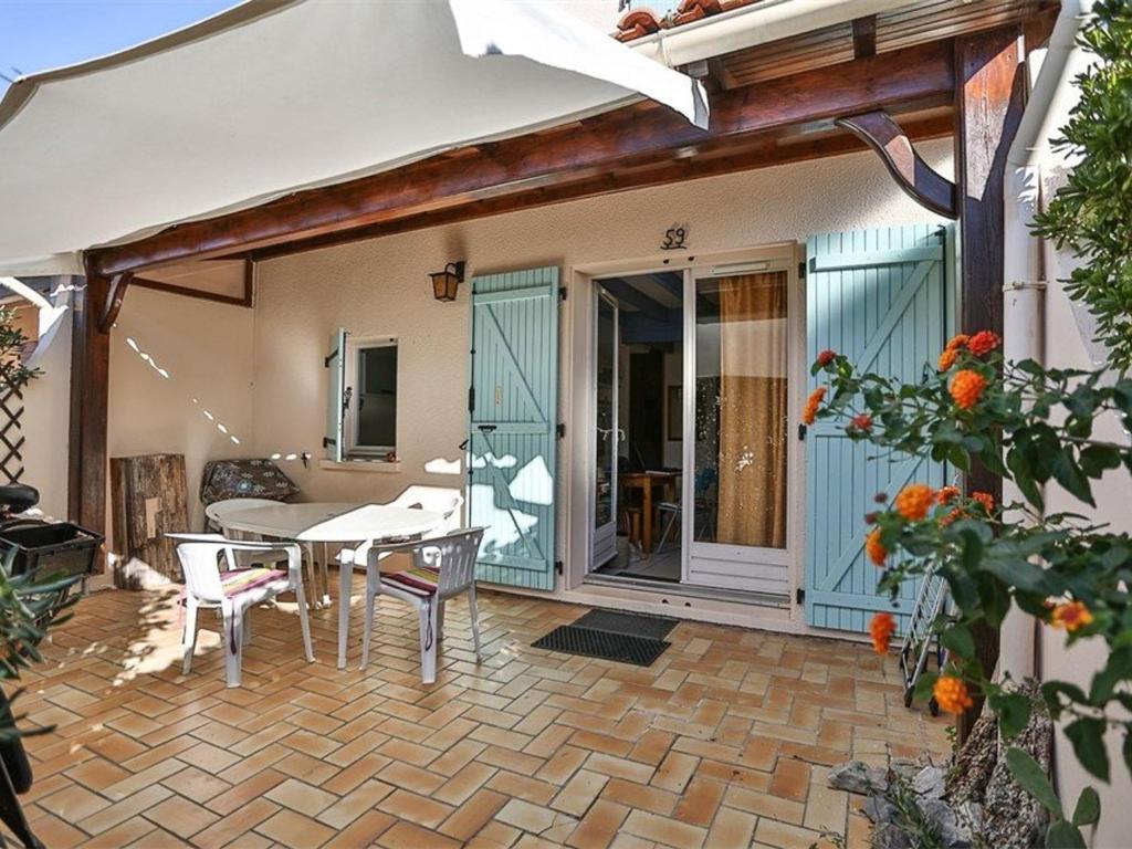 un patio avec une table et des chaises sur un patio dans l'établissement Pavillon T4 Mezzanine, 6 Pers, Terrasse, Parking, Proche Lac & Commerces, Port Leucate - FR-1-81-460, à Port-Leucate