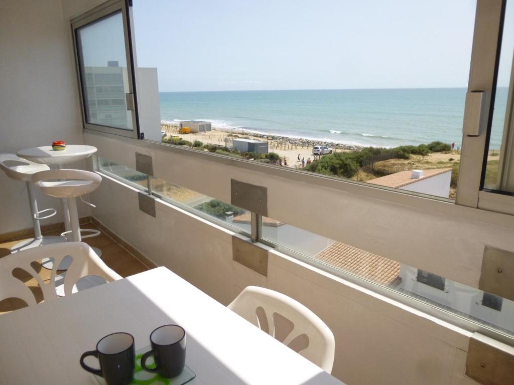 une cafétéria avec vue sur la plage depuis une fenêtre dans l'établissement Appartement 2 pièces, balcon, parking, animaux admis, plage à pied - FR-1-224C-58, à Saint-Hilaire-de-Riez
