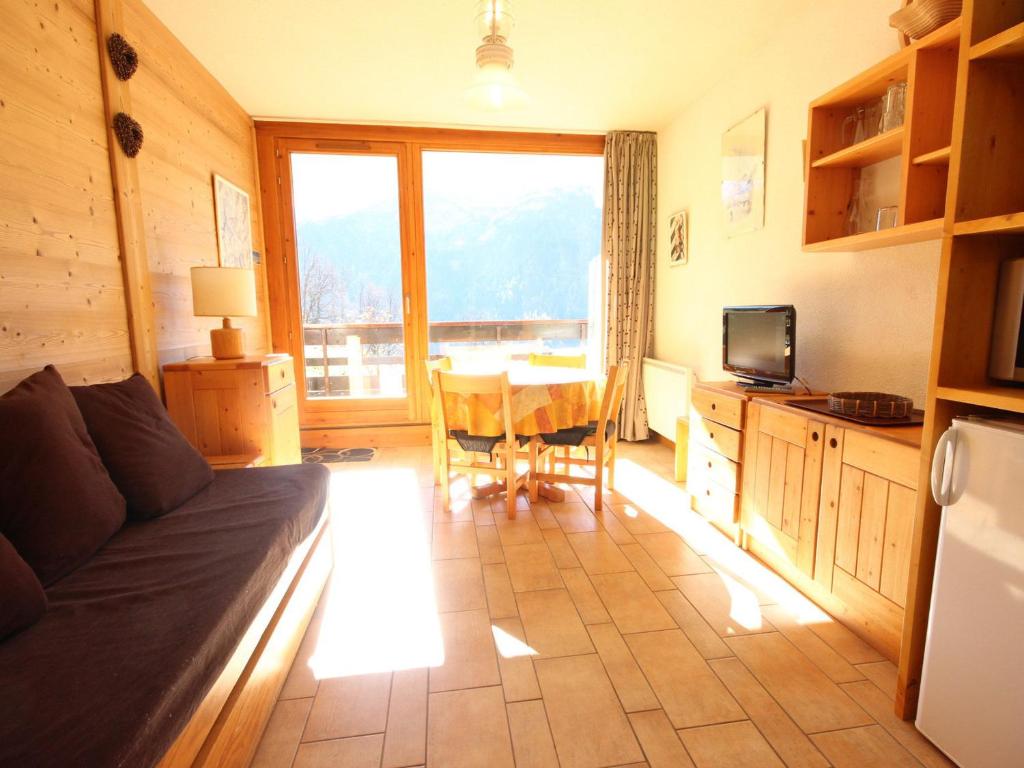 un salon avec un canapé et une table avec vue dans l'établissement Studio cosy 4 personnes proche commerces et pistes, animaux acceptés - FR-1-411-641, à Peisey-Nancroix