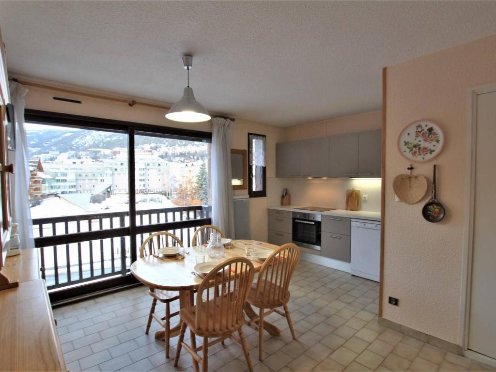 Il dispose d'un balcon et d'une cuisine avec une table et des chaises. dans l'établissement Appartement Briançon, 2 pièces, 5 personnes - FR-1-330C-103, à Briançon