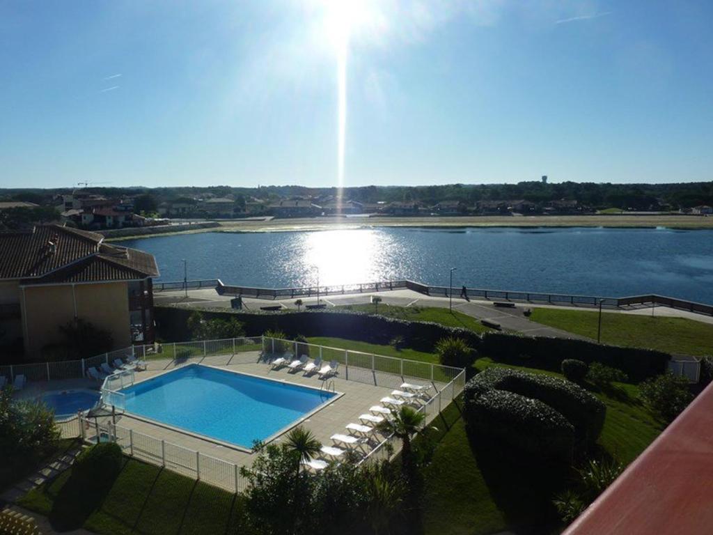 a swimming pool next to a large body of water at Appartement Vieux-Boucau-les-Bains, 3 pièces, 5 personnes - FR-1-379-115 in Vieux-Boucau-les-Bains