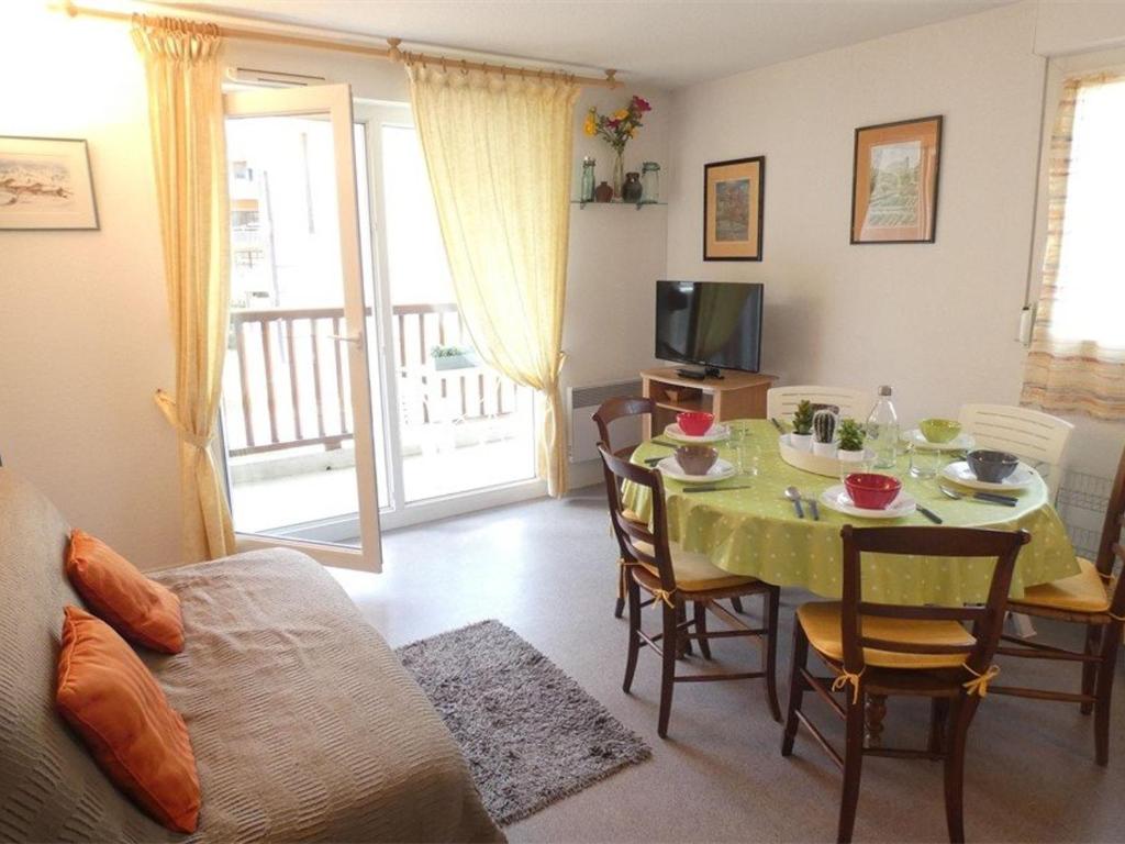 un salon avec une table et une télévision dans l'établissement Appartement T3 pour 6 à Saint-Lary-Soulan avec balcon, casier à ski, parking, ascenseur - FR-1-457-266, à Saint-Lary-Soulan