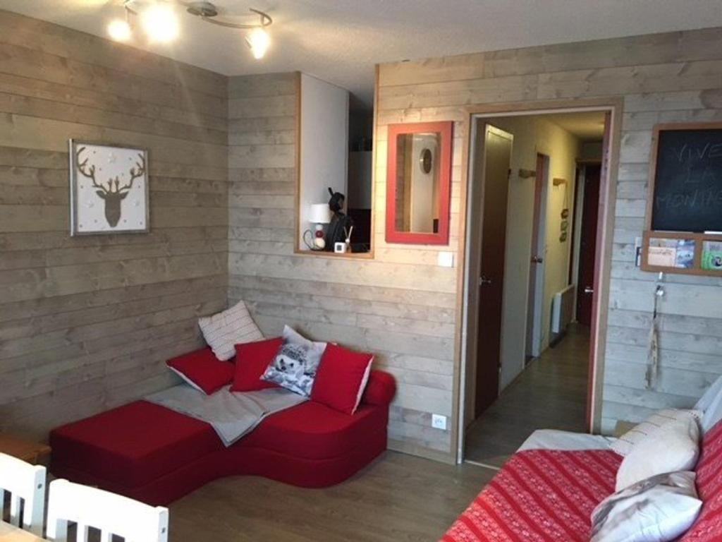 a living room with a red couch in a room at Studio cabine 5 pers, balcon, 80m pistes, animaux ok - FR-1-404-228 in La Mongie