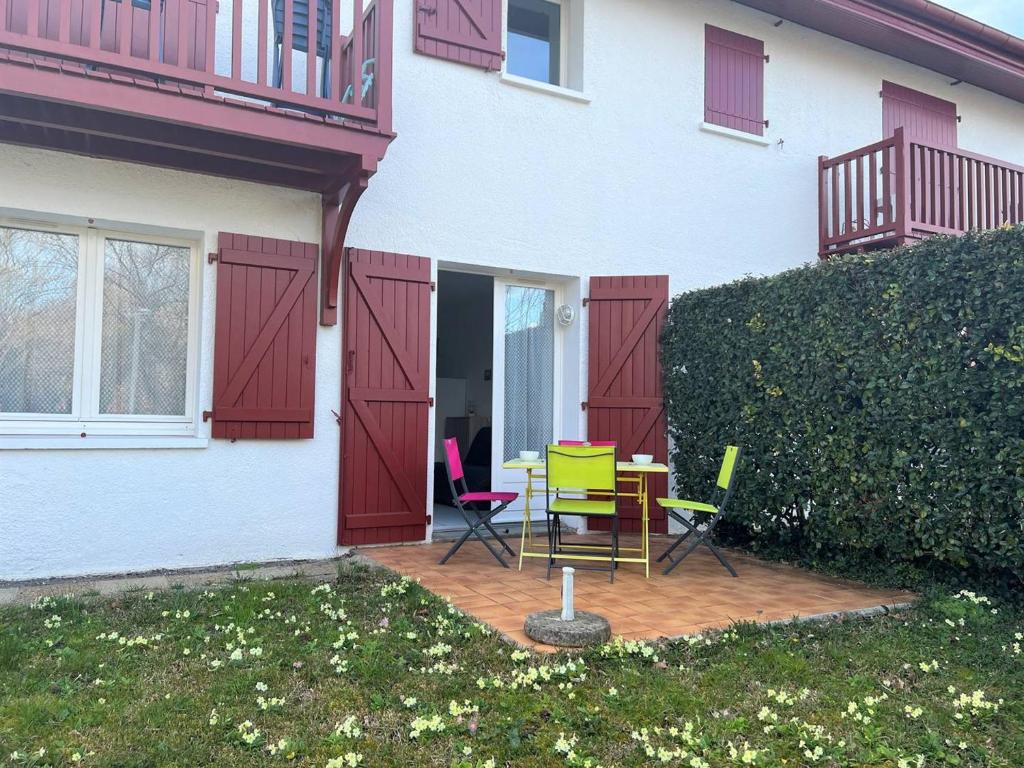 une terrasse avec une table et des chaises devant une maison dans l'établissement Appartement Cambo-les-Bains, 2 pièces, 3 personnes - FR-1-495-88, à Cambo-les-Bains