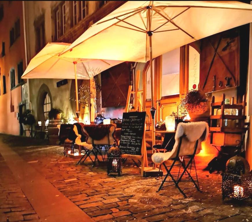 a restaurant with chairs and an umbrella on a street at Pünctchen in Chur