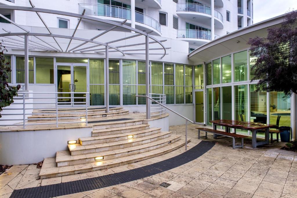 a building with stairs and a bench in front of it at Bunbury Hotel Koombana Bay in Bunbury