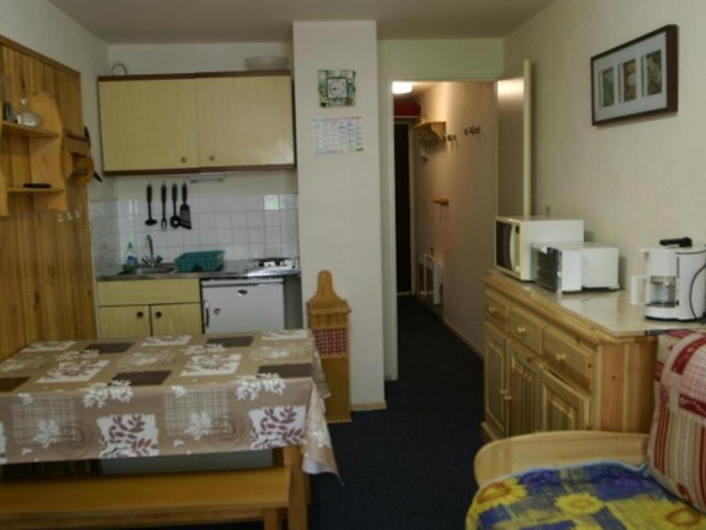 une cuisine avec une table et un comptoir dans l'établissement Studio cabine au Pleynet avec balcon, près des pistes - FR-1-557A-2, à La Ferrière